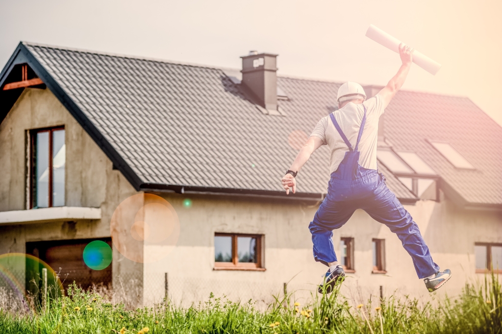 A builder celebrates outside a new build home, symbolising a successful construction VAT reclaim with expert guidance from a VAT specialist in Birmingham, showing how zero rated VAT UK rules apply to new build construction.