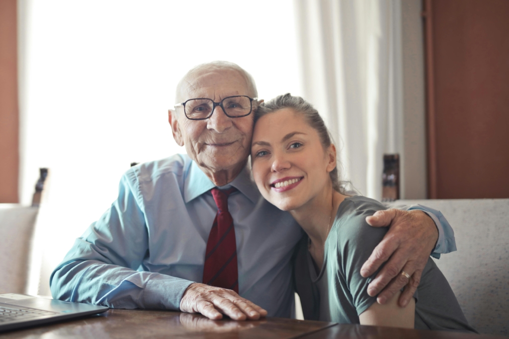 An elderly grandfather sitting with his smiling daughter at home, symbolising estate planning, family legacy, and tax-efficient property transfer in the UK.